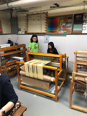 Students at a loom